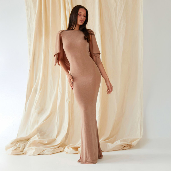 The model is wearing a Sarvin Mocha Backless Maxi Dress.