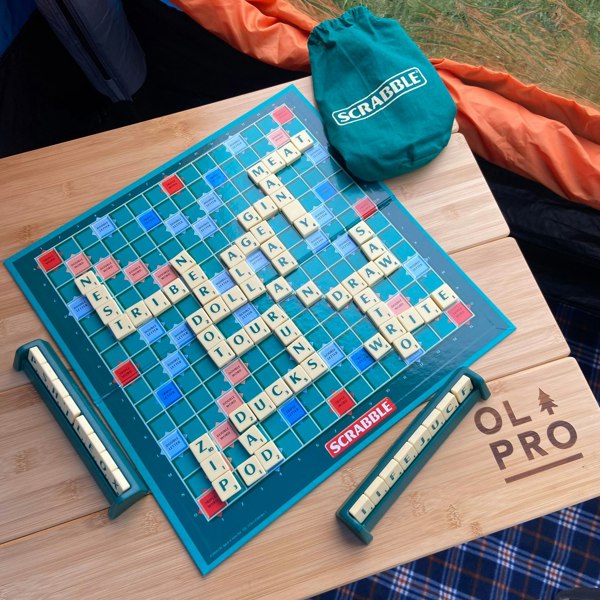 The OLPRO Bamboo Camping Table pictured in a campervan awning with a scrabble board being played with on top of the table.