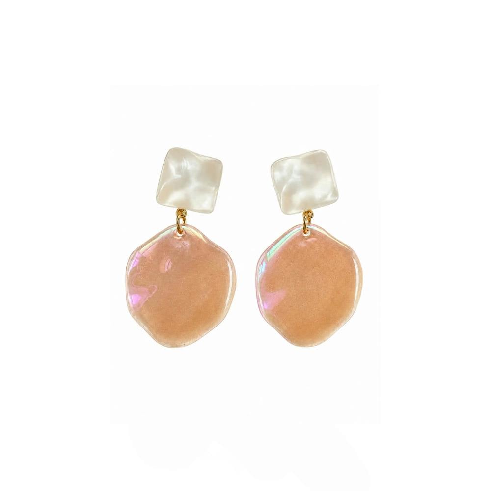A pair of dangling earrings with iridescent peach-pink irregular disc charms and white square stud tops, connected by small gold rings, shown on a plain white background.
