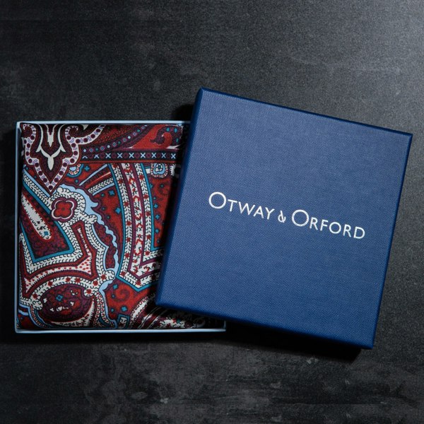 Intricate paisley design silk pocket square in burgundy, red, blue & cream by Otway & Orford folded in gift box