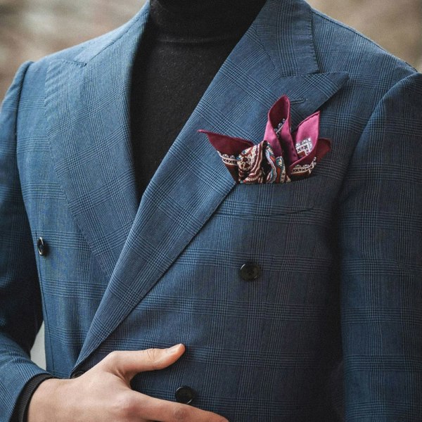 Labyrinth paisley design silk pocket square in burgundy, red, blue & cream by Otway & Orford folded in model