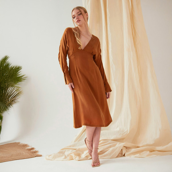 The model is wearing a Sarvin Mustard long sleeve Midi Dress.