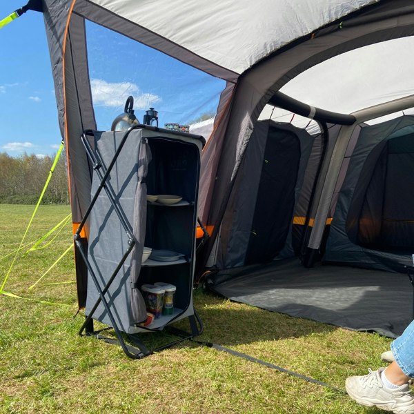 An image of the Collapsible Camp Storage Cupboard from OLPRO in a campervan awning pitched on a campsite.