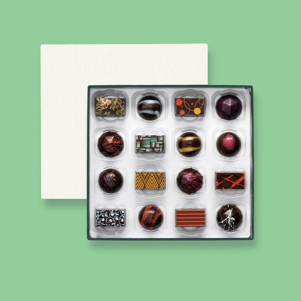 A box of 16 artisan vegan chocolates colourfully decorated 