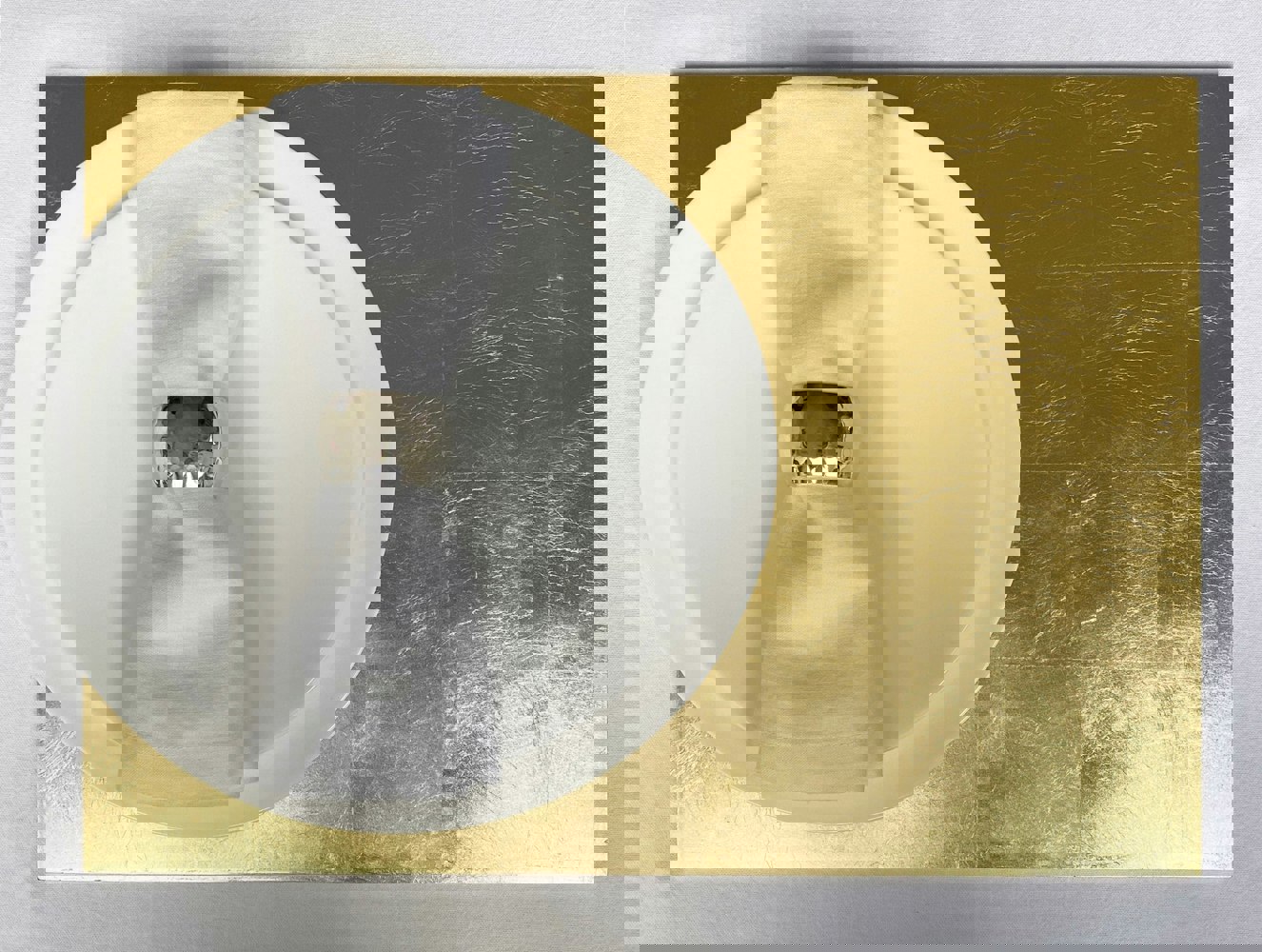 grand gold leaf placemat beneath plates and napkin