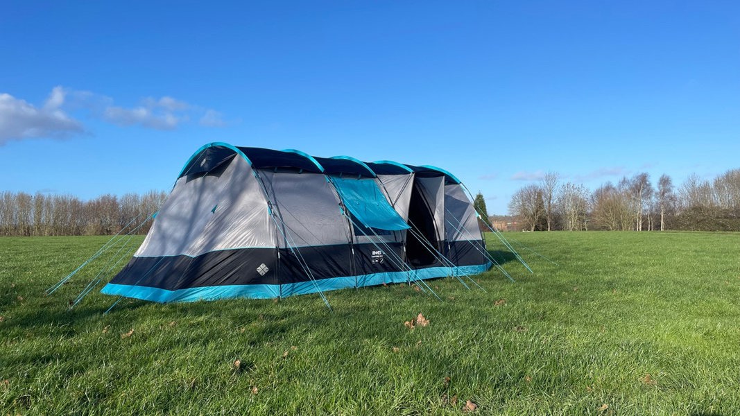 The Stafford 8.0 OLPRO x Ed Stafford sits on a campsite against a blue sky.