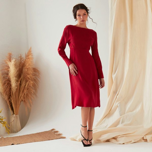 The model is wearing a Sarvin Long Sleeve Midi Dress.