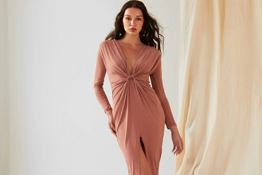 The model is wearing a Sarvin Twist Knot Front Dress with a slit.