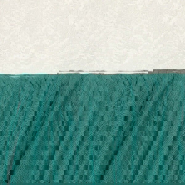 Close-up of teal fabric with a textured white background