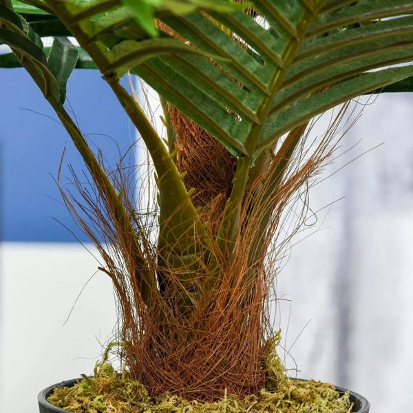 Close-up of faux rose tree trunk with brown stems and moss base in pot