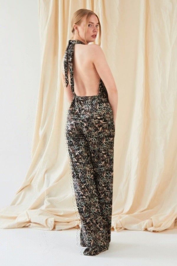 The back view of a woman wearing a Sarvin Floral Velvet Backless Jumpsuit.