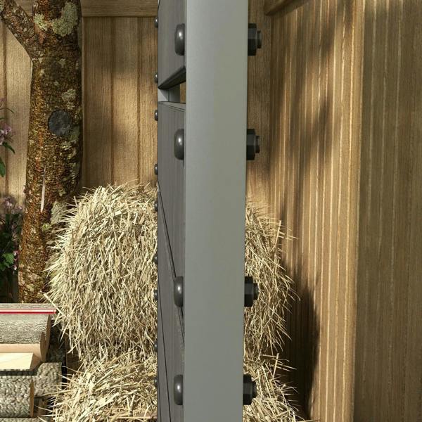 Dark grey planter box side panel with rivets, mounted against a wooden fence.