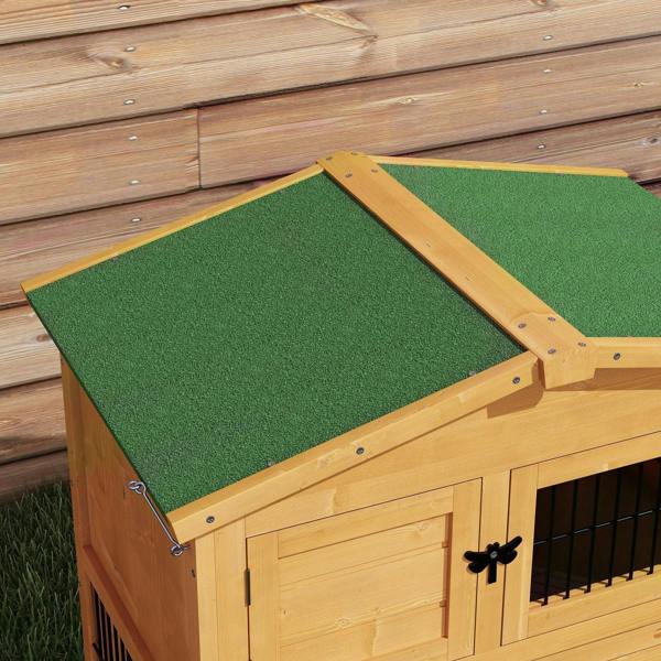 Green carpeted roof panel on a wooden rabbit hutch with wire-mesh side openings