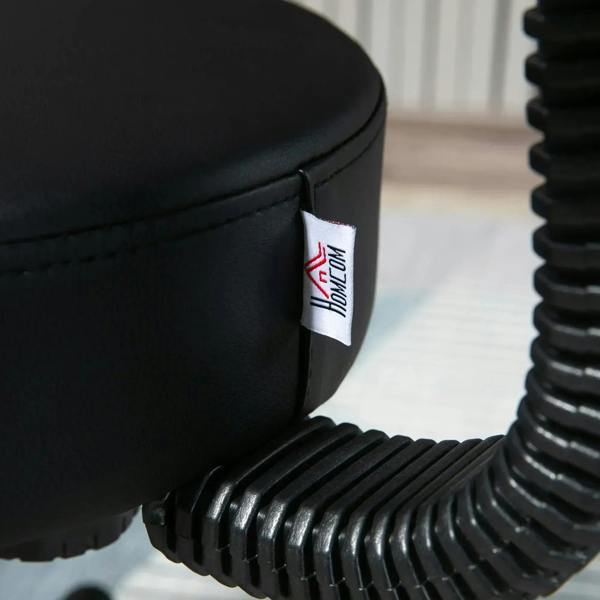 Black padded salon chair armrest detail with small branded fabric label