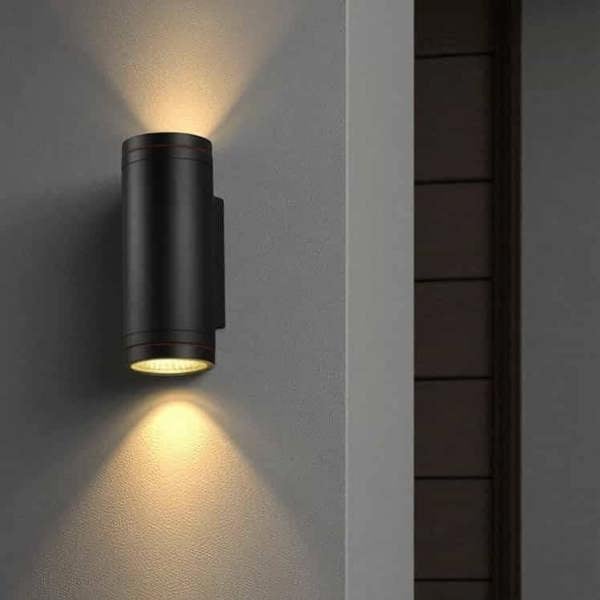 black large outdoor wall light installed on a white wall outside a modern house