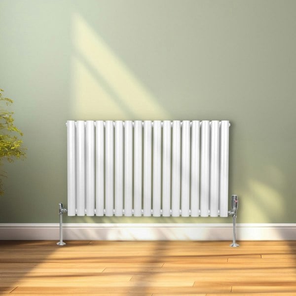 White oval column radiator, 600mm x 1020mm, featuring vertical fins and sleek design, mounted on a light green wall with wooden flooring