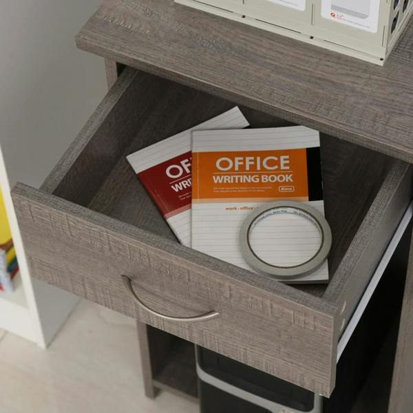 Grey utility drawer with handle, holding office books and writing supplies