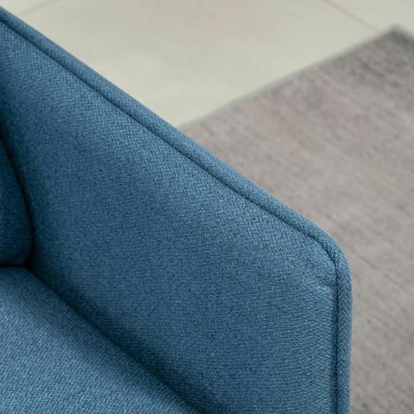 Blue upholstered armrest and side panel of a loveseat sofa