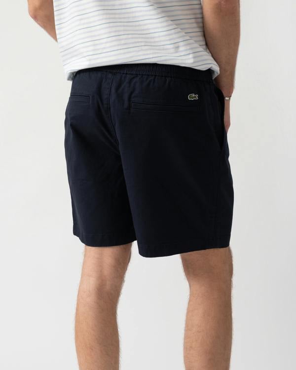 detail shot of a model wearing Lacoste Relaxed Fit Mens Stretch Cotton Shorts in Abysm HDE