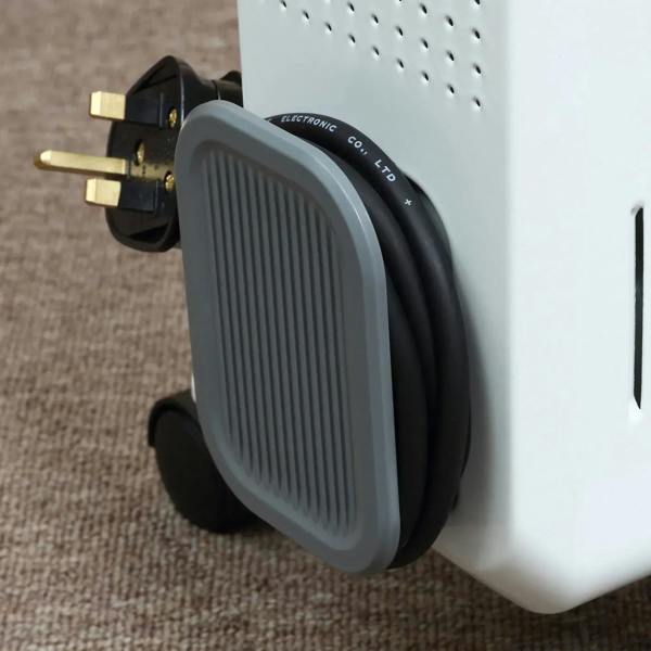 White oil-filled radiator heater with side carry handle and power plug near wheels