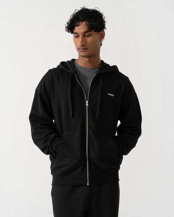 Man wearing  HUGO Dapozip Mens Cotton-terry zip-up hoodie with logo print - Black 001 with pockets