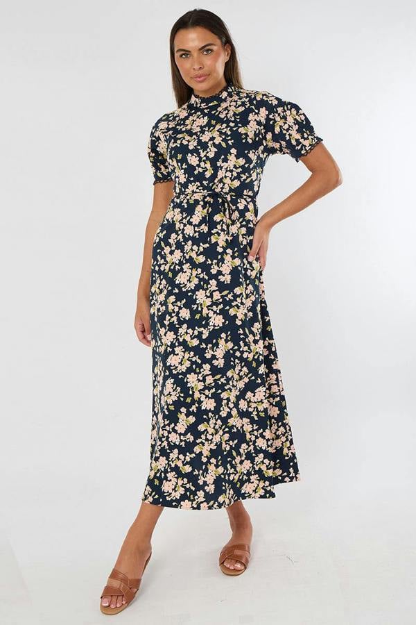 Woman wearing a navy floral dress on a white background