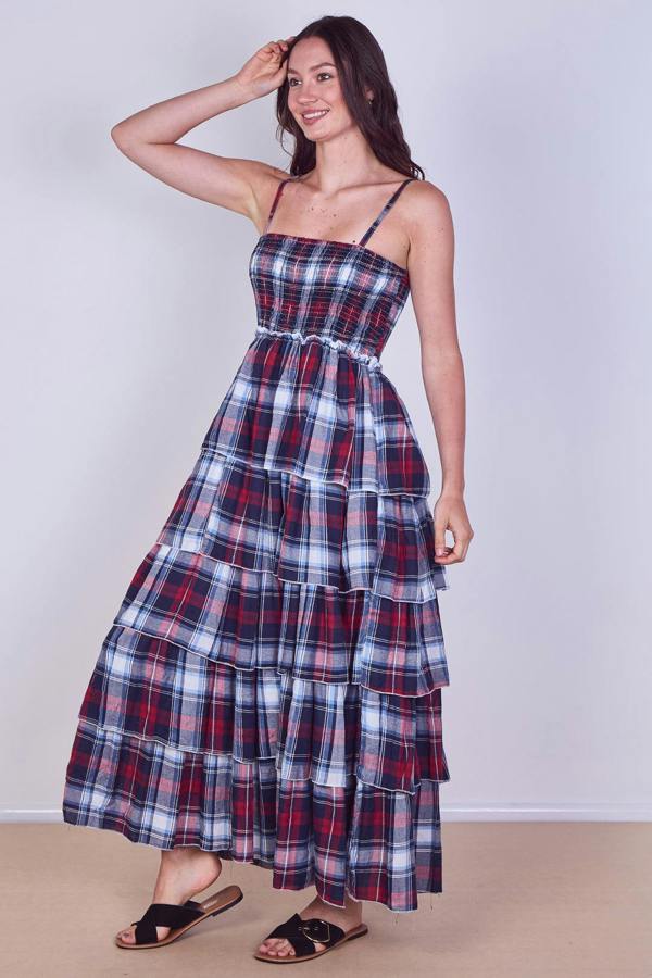 Woman wearing a plaid dress against a plain background