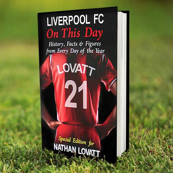Personalised Liverpool FC On This Day football history book showing a customised red shirt with name and number on a grass pitch.