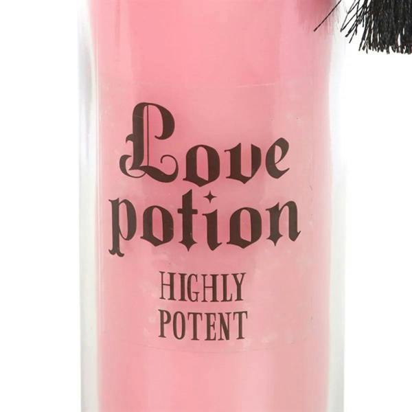Pink tube candle close-up with Love potion highly potent printed on glass