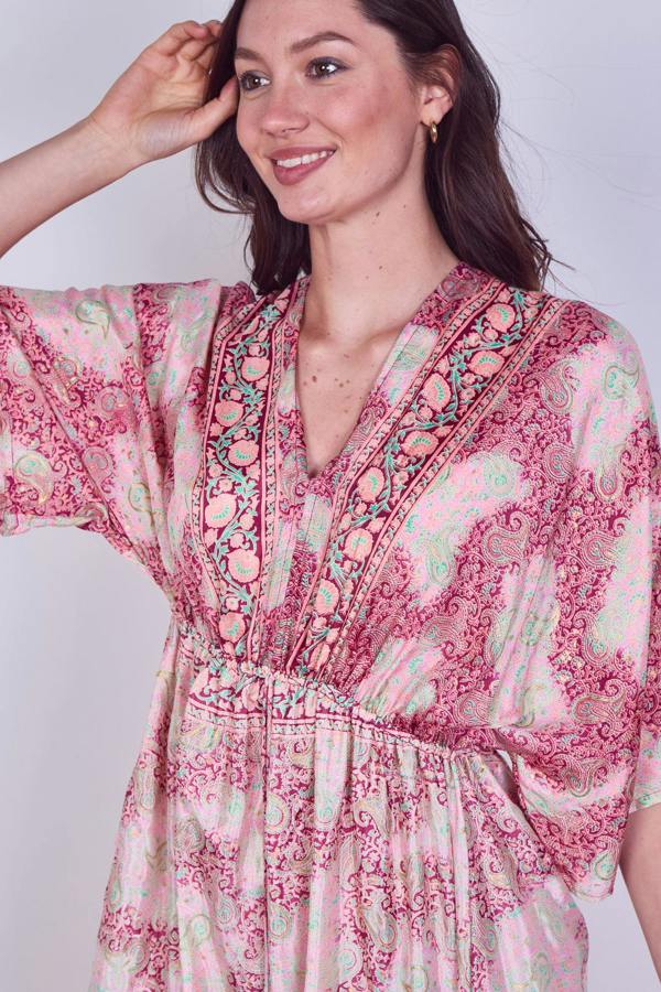 Woman wearing a pink floral dress against a white background