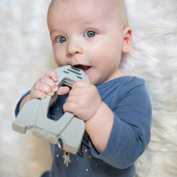 Baby chewing on a rocket shaped teething toy OrBITEr to soothe teething gums