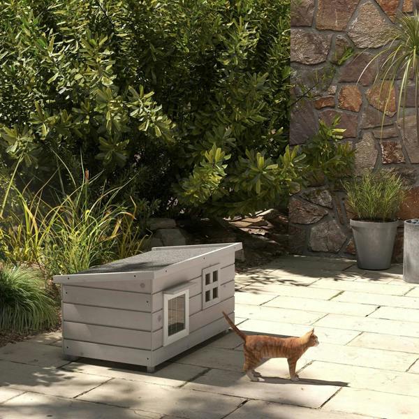 Grey wooden elevated cat house with front windows and openable roof outdoors