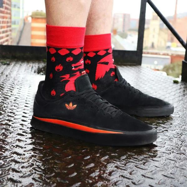 Red and black dragon flame bamboo crew socks on model, ribbed cuffs