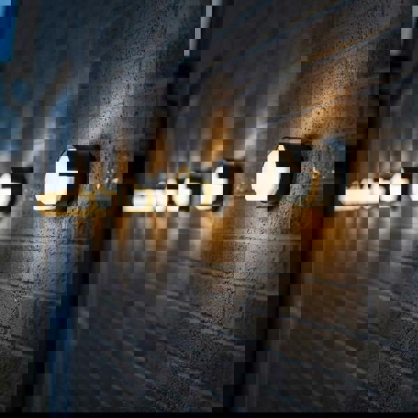 black outside wall lamp mounted in a line along the brick wall of a modern home 