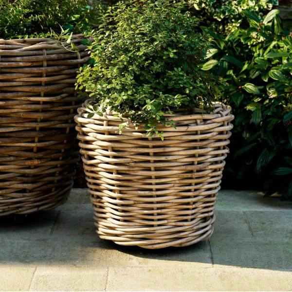 XL Cotswold handwoven rattan planter on wheels in a patio setting.
