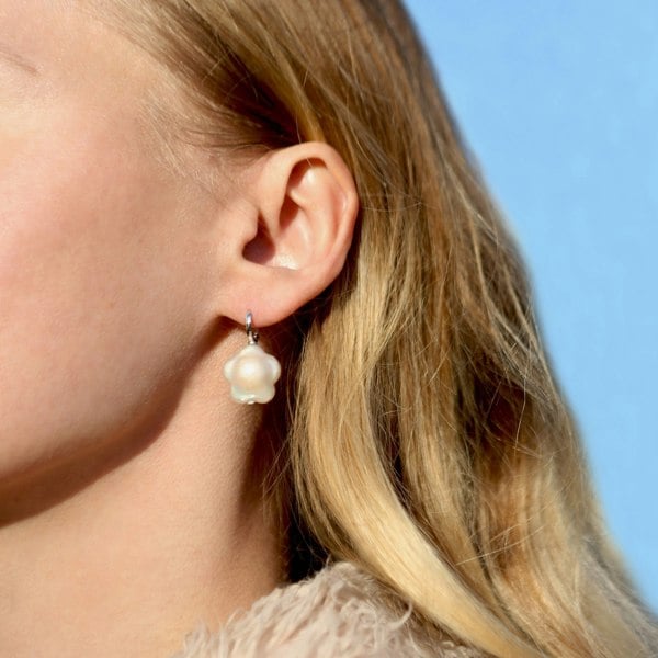 A model wearing flower-shaped pearl hoops.