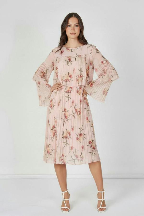 Woman wearing a pink floral dress against a white background