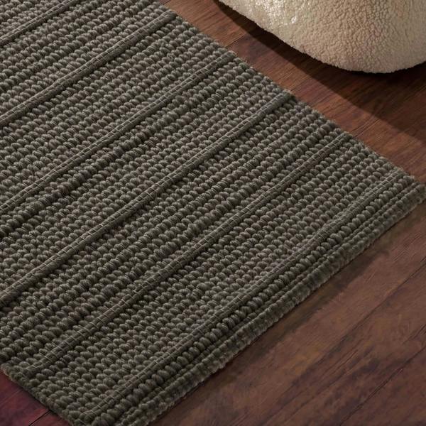 Textured green rug on a wooden floor