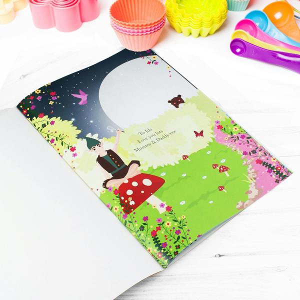 Open view of the Personalised Fairy Baking Adventure storybook displaying a custom printed message to Ida from Mummy and Daddy on a colorful fairy illustration page