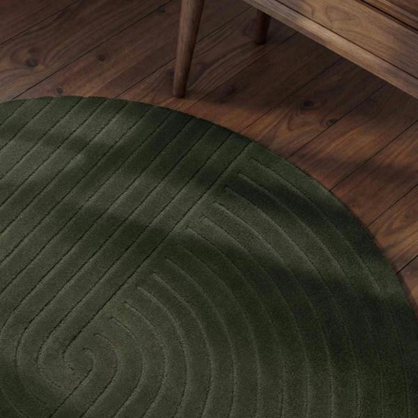 Green round rug on a wooden floor