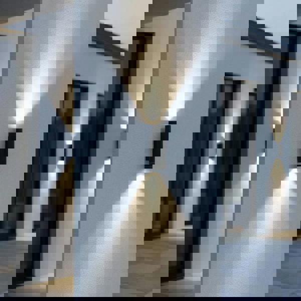 black outside up and down light mounted on a white column outside a modern house 