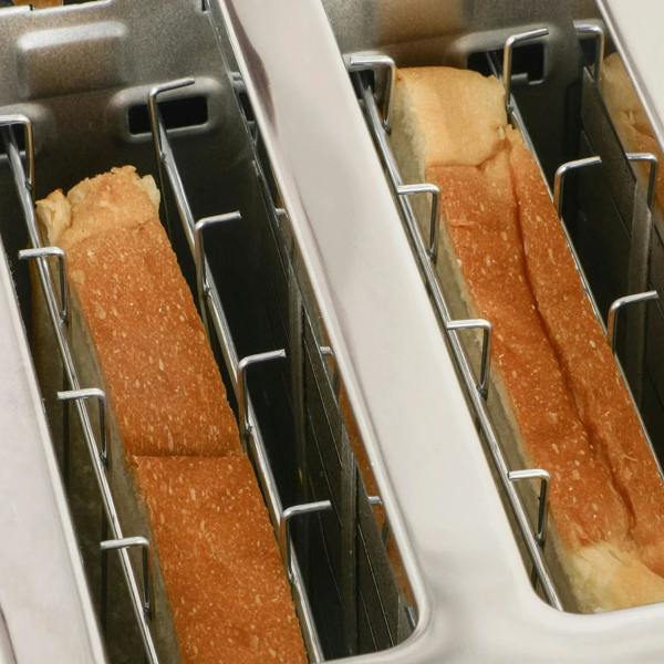 Close-up of black toaster slots with two browned bread slices inside