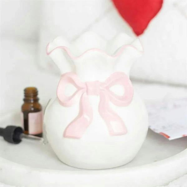 White oil burner with pink bow detail and scalloped rim