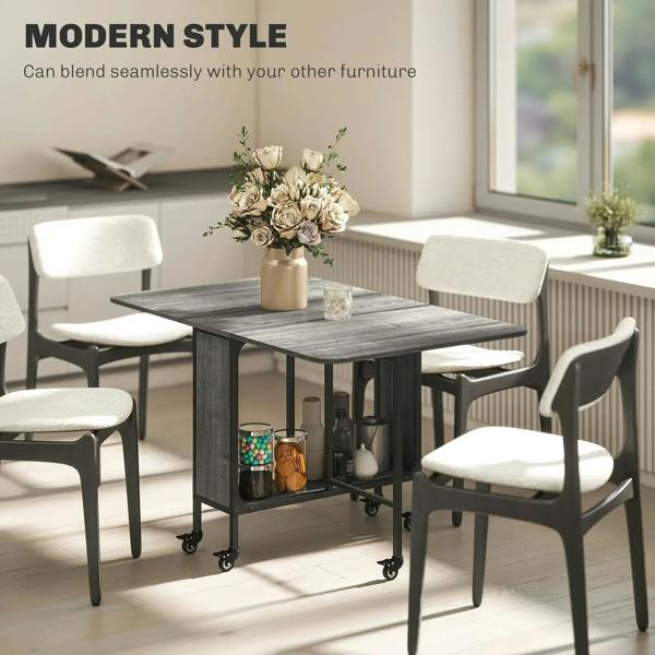 Grey drop-leaf dining table with black frame and side storage shelf on caster wheels