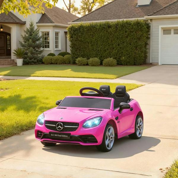 Pink kids electric ride-on car with LED headlights and Mercedes logo on a driveway