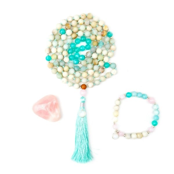 Kati Kaia Crystal Mala Necklace with pastel beads and turquoise tassel alongside matching bracelet and rose quartz stone