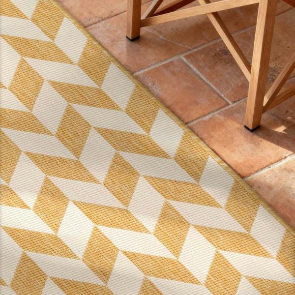 Yellow and white geometric patterned rug on terracotta tiles