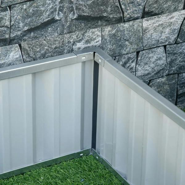 Inside corner of a dark gray metal raised garden bed with open-bottom interior