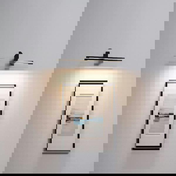 black picture light shown mounted on the wall over a picture