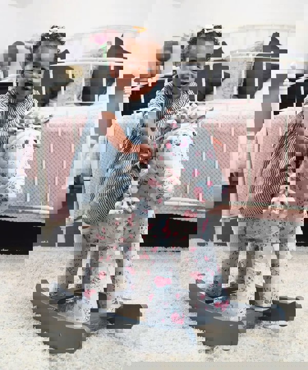 little girl rocking on rockinghorse in nursery 